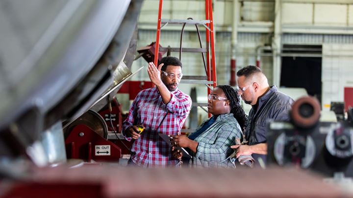 Autoshop mechanics analyzing a car